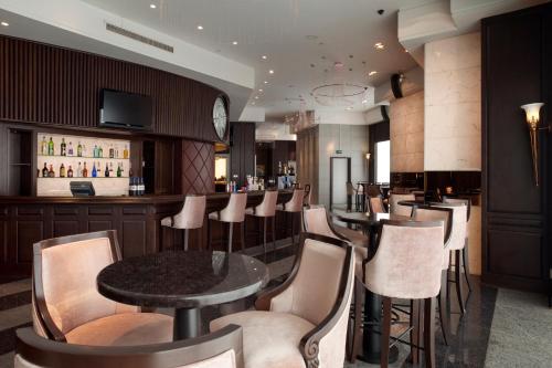 a restaurant with a bar with a table and chairs at Crowne Plaza Tianjin Binhai by IHG in Tianjin