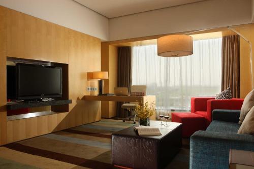 a living room with a television and a red couch at Crowne Plaza Tianjin Binhai by IHG in Tianjin