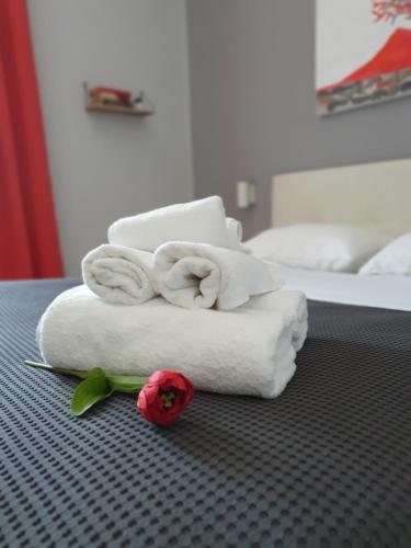 a pile of towels and a rose on a bed at Solfatara Suites B&B in Pozzuoli