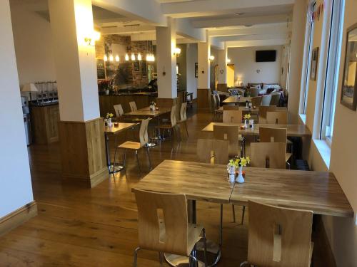 an empty restaurant with wooden tables and chairs at Gradbach Mill B&B in Buxton