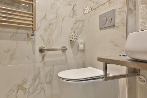 a white bathroom with a toilet and a sink at Hotel James Joyce in Trieste