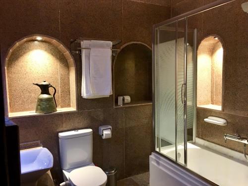 a bathroom with a toilet and a glass shower at Djorff Palace in Luxor