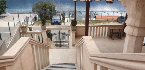 a house with a balcony with a car on the street at Apartments Klakor PS in Tivat