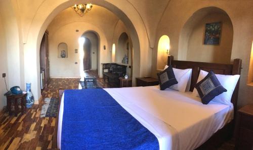 a bedroom with a large bed with a blue blanket at Djorff Palace in Luxor