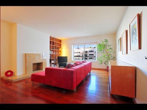 a living room with a red couch and a fireplace at Confortable & contemporary - Expo in Lisbon