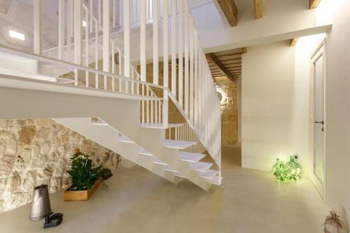 a staircase in a house with a stone wall at Hotel S'Estil-let in Es Migjorn Gran