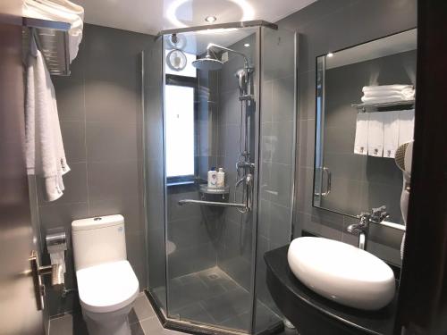 a bathroom with a toilet and a glass shower at Oda Theme Apartment (Guangzhou Wanshengwei Pazhou Convention and Exhibition Center) in Guangzhou