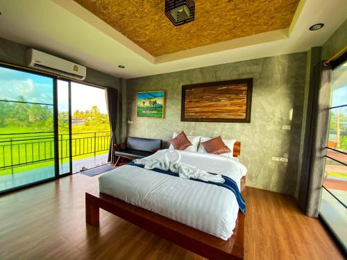 a bedroom with a bed and a large window at Idin Klinna @Huapa in Ranot