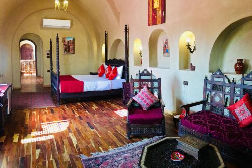 a bedroom with a bed and two chairs in a room at Djorff Palace in Luxor