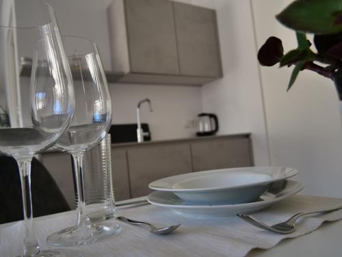 stół z dwoma kieliszkami i talerzem na nim w obiekcie Apartments Sabine G w Meranie
