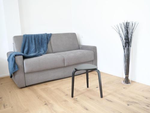 a living room with a couch and a stool at Apartments Sabine G in Merano