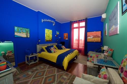 um quarto azul com uma cama e um sofá em Chambres d'hôtes Le Regent em Hyères