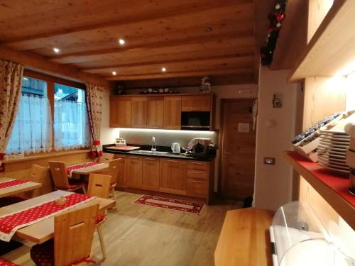 a kitchen with wooden cabinets and a table and chairs at B&B Daina Hame in Sappada