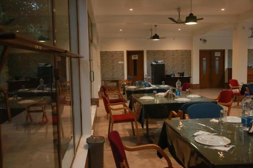 a dining room with tables and chairs and a room with at Balishira Resort Ltd. in Sreemangal