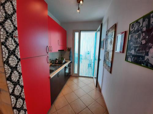 a kitchen with red cabinets and a red wall at Casetta Manila in Uggiano la Chiesa