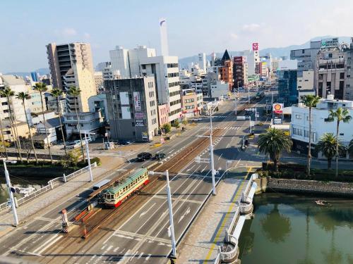 a city street with a bus and a bus at Hotel Takasago in Kochi