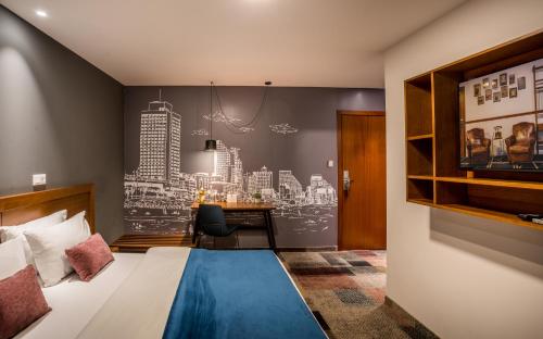 a hotel room with a bed and a desk at Embassy Hotel Tel Aviv in Tel Aviv