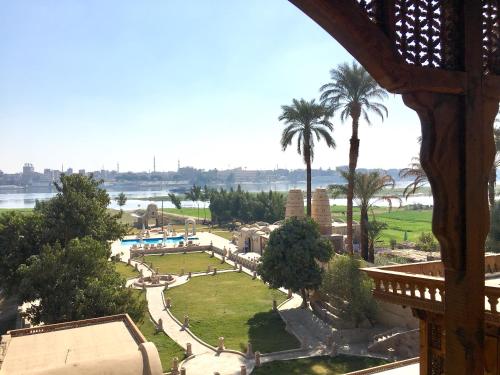a view of a park with palm trees and water at Djorff Palace in Luxor