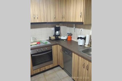 a small kitchen with wooden cabinets and a sink at Fanari Maisonette in Fanari