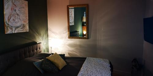 a bedroom with a bed with a mirror and a lamp at La Cour Du Puits Chambre Matcha in Cormeilles