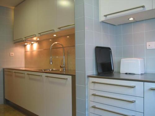 uma cozinha com um lavatório e uma bancada em Confortable & contemporary - Expo em Lisboa