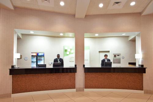a man standing in front of a counter in a public restroom at Holiday Inn New Orleans West Bank Tower, an IHG Hotel in Gretna