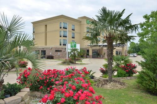 a hotel with flowers in front of a building at Holiday Inn Montgomery Airport South by IHG in Hope Hull