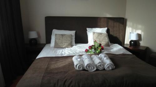 a bed with towels and a bouquet of flowers on it at Apartament 50m od plaży z garażem in Władysławowo