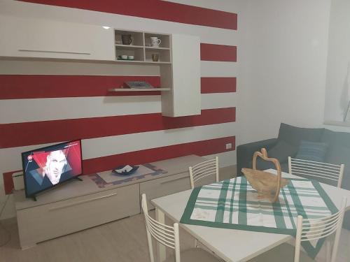 ein Wohnzimmer mit einem Tisch und einem TV an der Wand in der Unterkunft Felicity5terre in La Spezia
