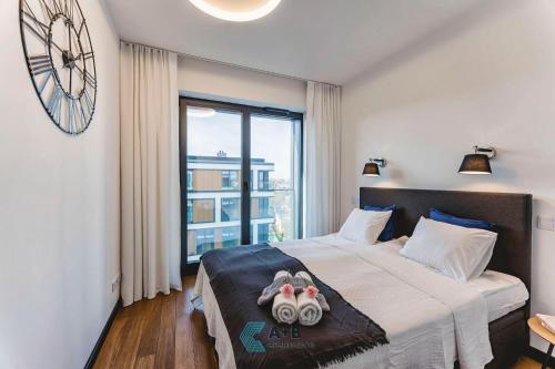 1 dormitorio con 1 cama con reloj en la pared en Apartamenty Active Residence typu Superior, en Lublin