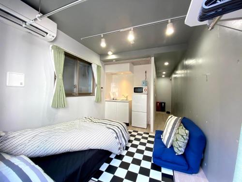 1 dormitorio con 1 cama y suelo a cuadros en Belle harmonie togoshi101, en Tokio