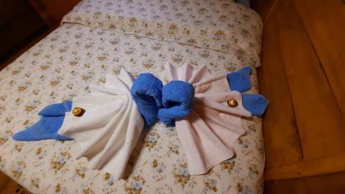 a white bed with blue stuffed animals on it at Etno selo EDEN in Žeravački Potok