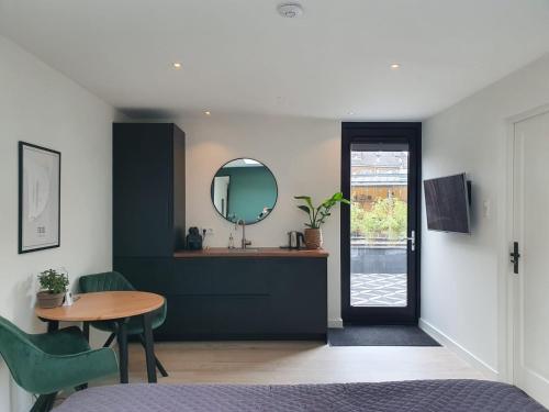 a room with a sink and a table and a mirror at Studio Smidt in Den Burg