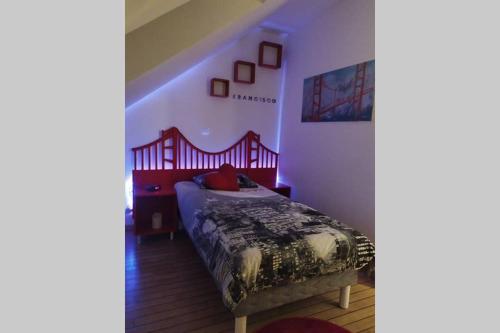 a bedroom with a bed with a red head board at LOGEMENT ATYPIQUE BIEN ETRE AU CŒUR DE LA NATURE in Quimper