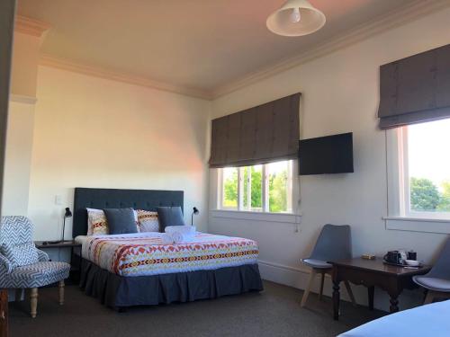 a bedroom with a bed and two windows at Penmarric House - Self Check-in in Cambridge