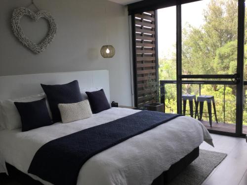 a bedroom with a large bed and a large window at The Moonah Apartment 29 in Fingal