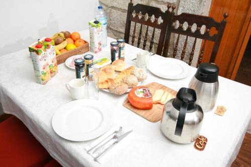 a white table with white plates and food on it at Dias House in Viana do Castelo