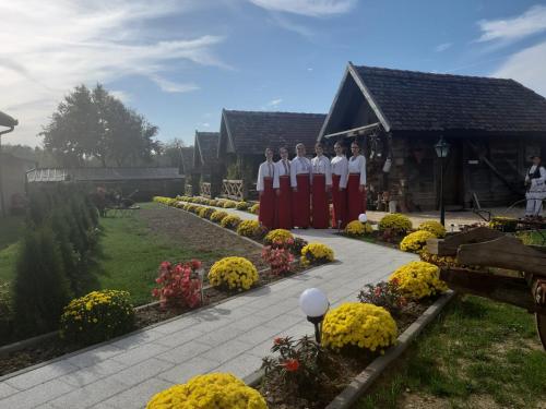 a group of people standing in front of a garden at Etno selo EDEN in Žeravački Potok