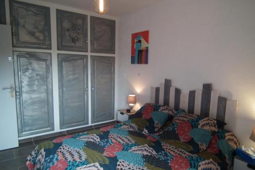 - une chambre avec un lit et une couette colorée dans l'établissement Appartement, à Saint Cyprien Plage