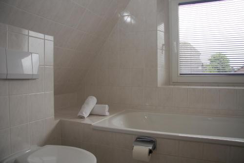 uma casa de banho com uma banheira, um WC e um lavatório. em Reethof em Tinnum