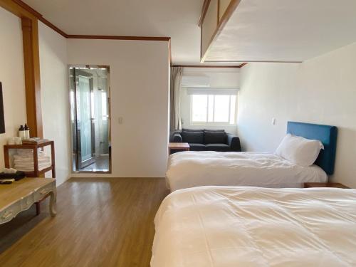 ein Hotelzimmer mit 2 Betten und einem Wohnzimmer in der Unterkunft Natural Essence of Hot Spring in Jiaoxi