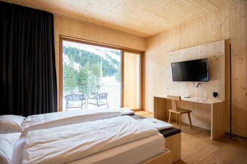 Un pat sau paturi într-o cameră la Campra Alpine Lodge & Spa