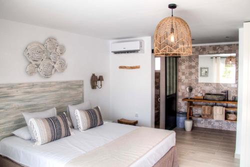 1 dormitorio con cama blanca y lámpara colgante en Finca Pura, Clothing Optional Guestrooms, en Elche