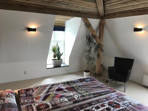 ein Schlafzimmer mit einem Bett und einem Stuhl und einem Fenster in der Unterkunft Spinnerei in Spechtholzhock