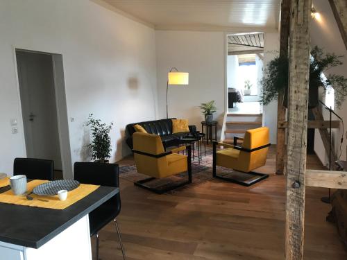 a living room with yellow chairs and a table at Spinnerei in Spechtholzhock