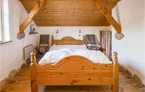Beautiful Home In Thyholm With House A Panoramic View في Thyholm: غرفة نوم مع سرير خشبي كبير في غرفة