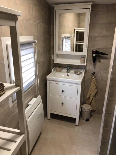 une salle de bain avec un lavabo blanc et un miroir dans l'établissement Provence Luberon Bonnieux Location Gite Chez Basile, à Bonnieux