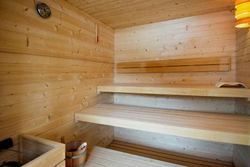 a sauna with wooden walls and wooden shelves at Campra Alpine Lodge & Spa in Olivone