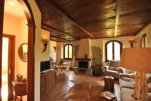 a living room with wooden ceilings and a living room with a fireplace at B&B Casale delle farfalle in Tornolo