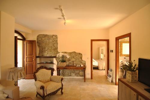 a living room with a stone fireplace and a television at B&B Casale delle farfalle in Tornolo